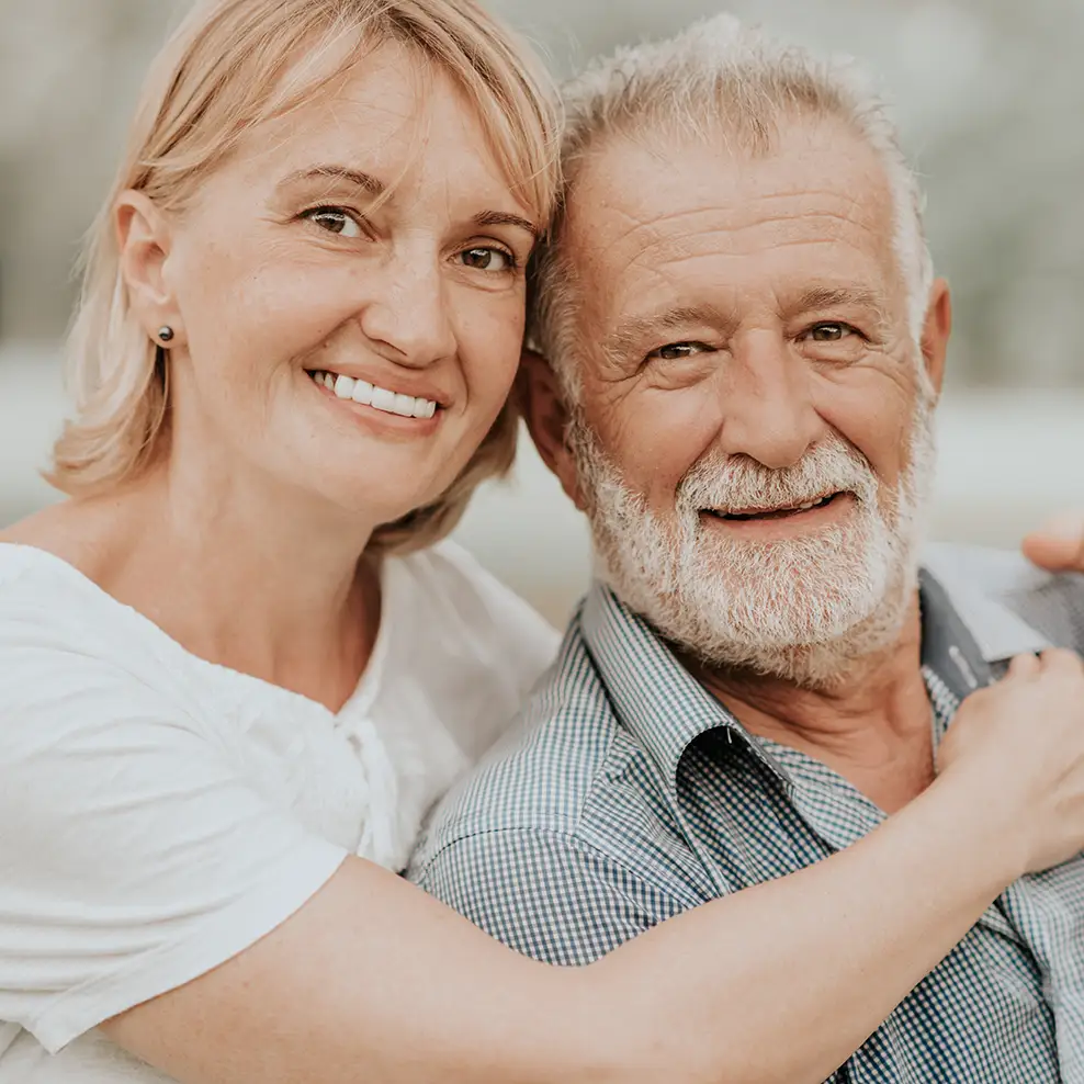 Elderly couple with the woman hugging the male in the image.